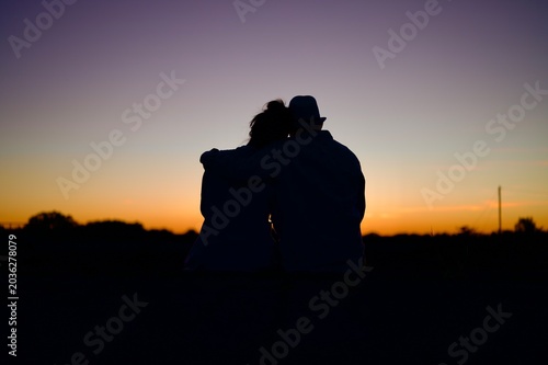 Romantic Couple Sitting Together on Cobblestone Path at Sunset