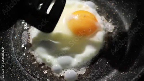 Sunny side up fried egg cooking in a pan.