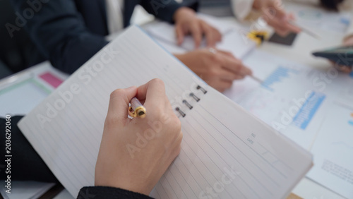 Foto Business person taking notes during office meeting