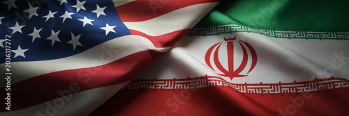 United States and Iran national flags intertwined in dramatic folds representing international relations and diplomacy.