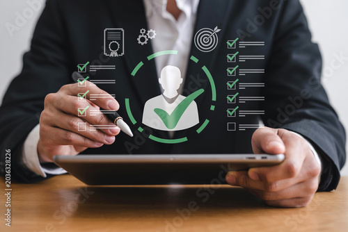 Businessman using digital tablet for human resources management and candidate selection process with virtual interface icons.