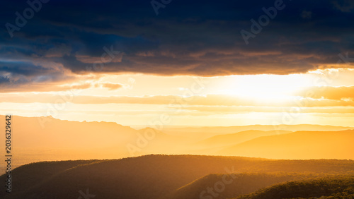 Mountain vista landscape in Grampians National Park, Victoria, Australia, during a bright, dramatic sunset with stormy clouds. 