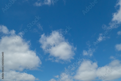 White soft clouds moving slowly across a blue sky