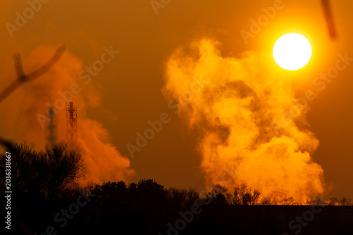 Canvas Print Golden winter sunset drenches colossal industrial steam plume