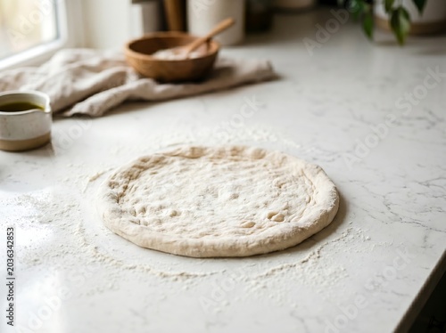A flattened pizza dough being stretched into a circle