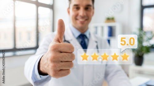 Smiling doctor giving thumbs up with five star rating, healthcare review, patient satisfaction and medical service quality concept.