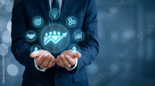 Businessman holding glowing strategy icons, team growth, innovation and leadership success concept with copy space.