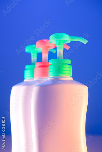 Object Series : Three white pump bottles line up in a row under futuristic neon lighting against a solid blue background.