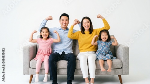 Family Power Pose: A joyous family of four, parents and two daughters, sit on a couch flexing their muscles, radiating strength and happiness.