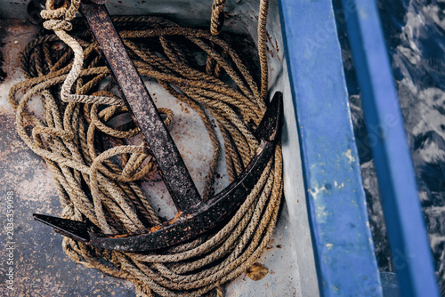 Fotografie Metal anchor lying on board boat sailing on lake, sea vacation on ship