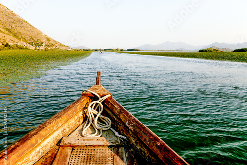 Photos Wooden boat yacht sailing on water Skadar Lake in Montenegro, summer landscape