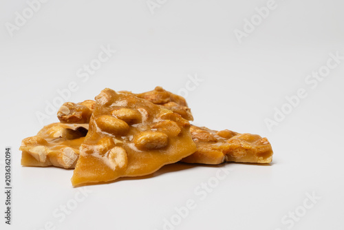 Closeup of Homemade Peanut Brittle on a White Background