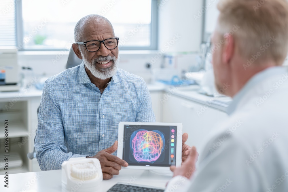 Fototapeta premium Dentist consulting senior patient on sleep apnea treatment with tablet in dental office