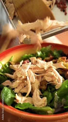 Healthy chicken Caesar Salad Preparation: Adding Steamed Chicken Breast