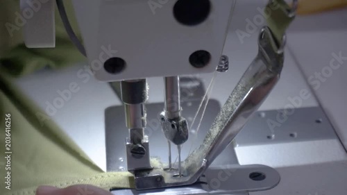 Close-up of a professional sewing machine stitching fabric, highlighting the intricate process of textile creation and craftsmanship