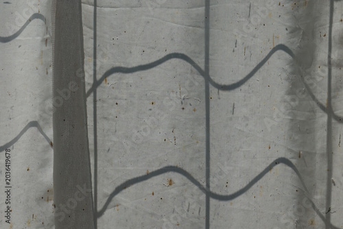 Abstract shadow pattern on translucent fabric surface