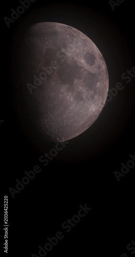 Detailed vertical moon timelapse background with lunar craters and soft glow in the pitch black night sky, perfect for smartphone wallpaper and stories.