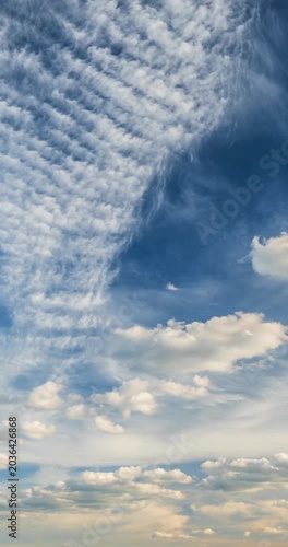 Beautiful vertical cloudscape timelapse background with fluffy clouds flying across the bright blue sky, perfect for social media stories.
