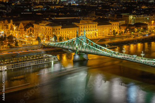Bild auf Leinwand Liberty Bridge and the University of Economics campus at night in Budapest