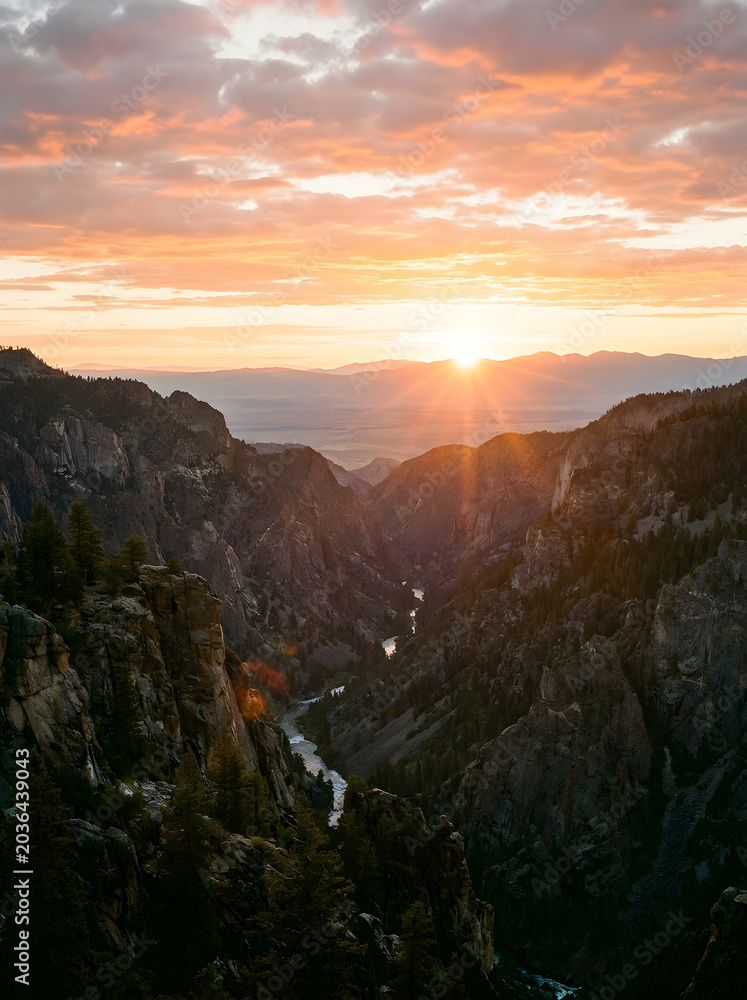 Obraz premium Breathtaking sunrise over a deep mountain canyon with a winding river