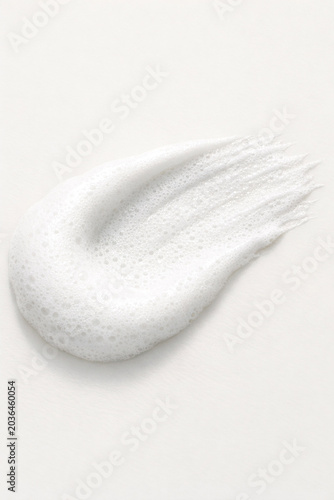 Close-up image of soap bubbles forming and dissipating on water surface.