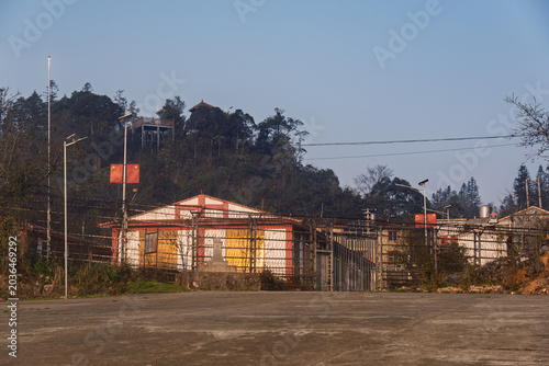 Tableau sur toile Quiet border checkpoint buildings near the Vietnam China frontier surrounded by hills and rural infrastructure during soft evening light