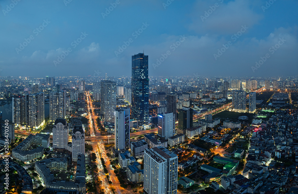 Obraz premium Blue hour panorama of Pham Hung Me Tri intersection surrounded by illuminated modern skyline in Hanoi Vietnam.