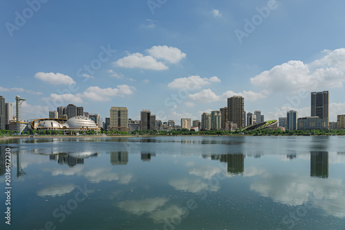Calm waters of Cau Giay Lake reflect modern skyline and blue skies in a rapidly developing Hanoi urban district.
