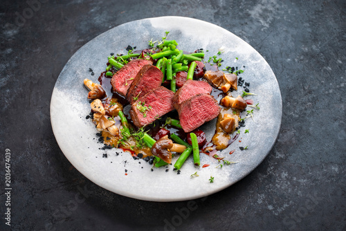 Bild auf Leinwand Roasted venison tagliata steak from haunch with wild mushrooms volvaria volvacea