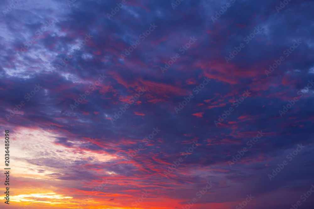 Fototapeta premium Dramatic golden hour sky with colorful sunset clouds,A breathtaking panoramic view of a dramatic golden hour sky, featuring vibrant orange, pink, and purple sunset clouds scattered across a deep blue 