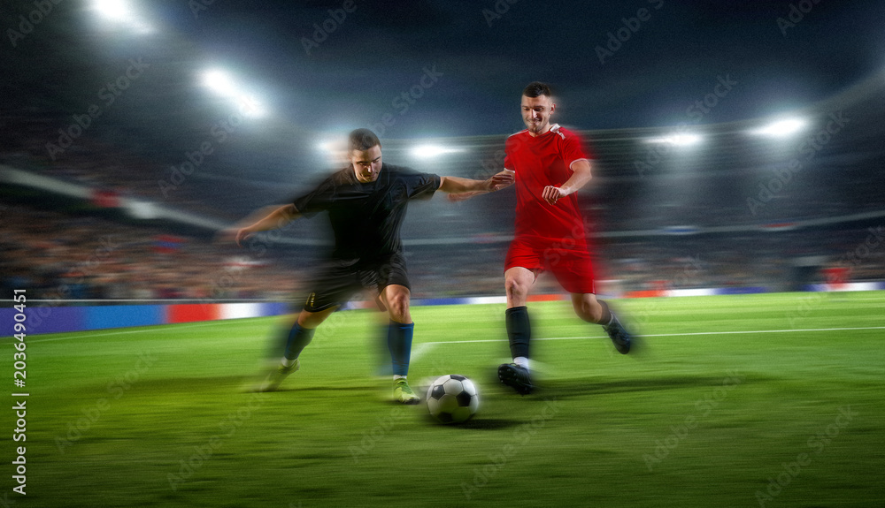 Naklejka premium Soccer players battling for ball with motion blur in fast night game. Concept of football rivalry, sports speed, club competition, match broadcast and athletic gear promotion.