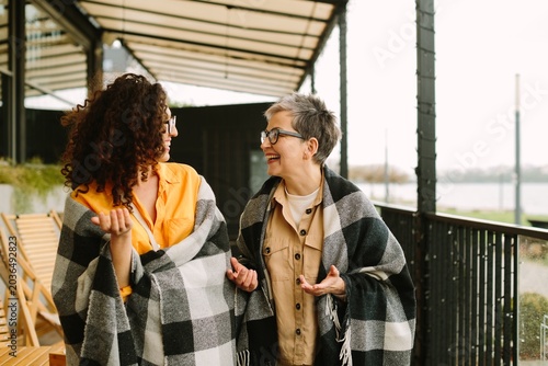 Cheerful women enjoying friendship, walking outdoors, laughing together