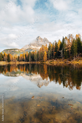 Scenic Alpine Lake in Autumn, Vibrant Fall Forest and Distant Mountain Peak on the Horizon in Natural Light