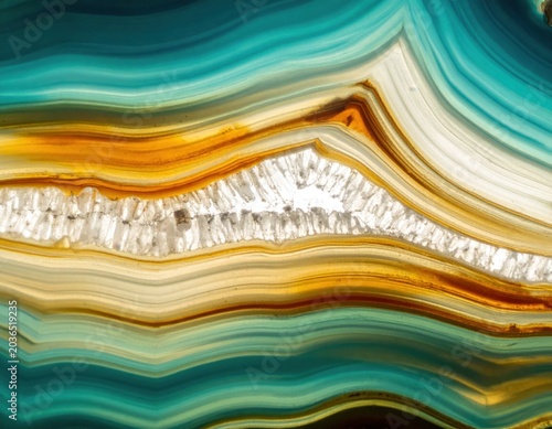 Stunning close up macro shot of a vibrant blue and golden yellow natural agate mineral stone displaying intricate banded patterns and a bright crystalline geode formation center