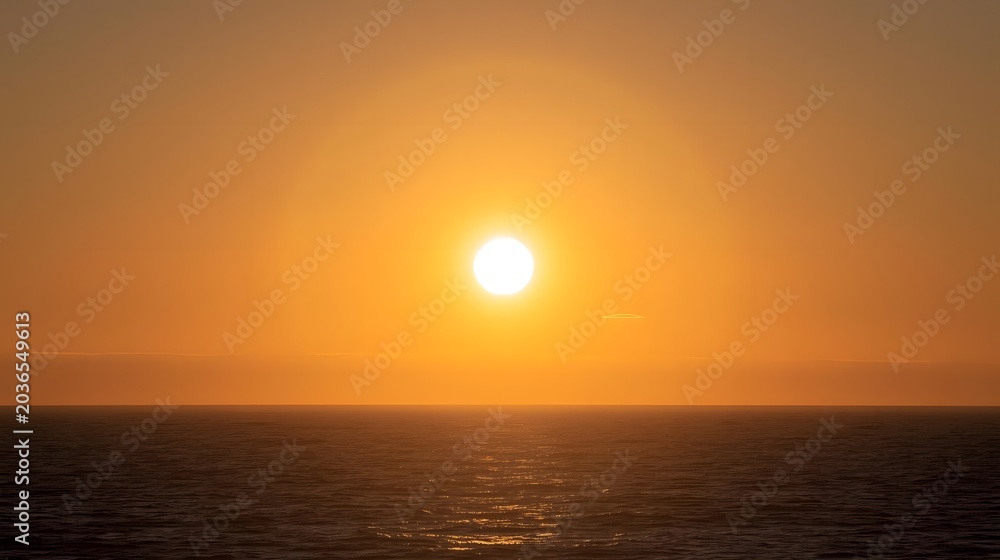 Obraz premium Sunrise over calm open ocean waters with golden sunlight