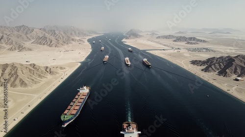 Aerial drone perspective of the Strait of Hormuz with oil tankers and cargo ships traveling through strategic Middle East maritime trade route