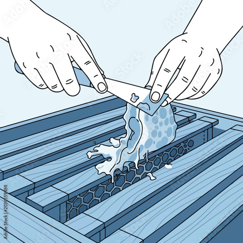 Hands scraping wax from honeycomb frame