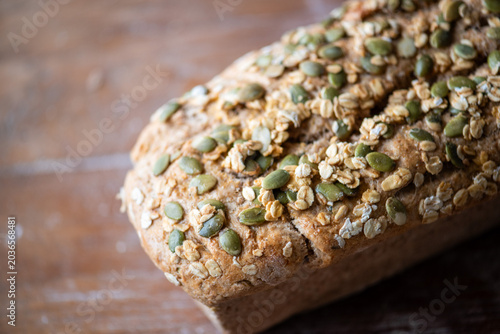 Photos Close-up of a loaf of multigrain bread with seeds on a wooden table