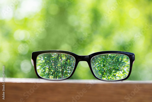 Photos Clear vision through spectacles on blurred nature background, choosing glasses for sharp view and eyesight correction for focused view