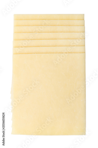 Stack of Cheddar cheese slices. Off-white Cheddar slices, a relatively hard natural cheese of firm, dense and crumbly texture, originally from England. Isolated, close-up from above, over white. Photo