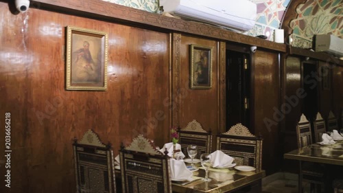 Slow motion 4K video of a traditional restaurant interior in Cairo, Egypt, featuring ornate wooden decor, elegant dining tables, and authentic Arabic design.