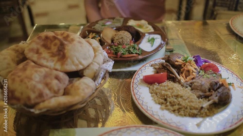 Slow motion close-up of traditional Egyptian dishes and fresh pita bread served at authentic restaurant in Cairo, Egypt. Delicious Middle Eastern cuisine.