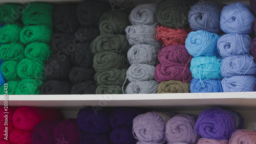 Quadro su tela Rows of colorful soft yarn skeins on a shelf