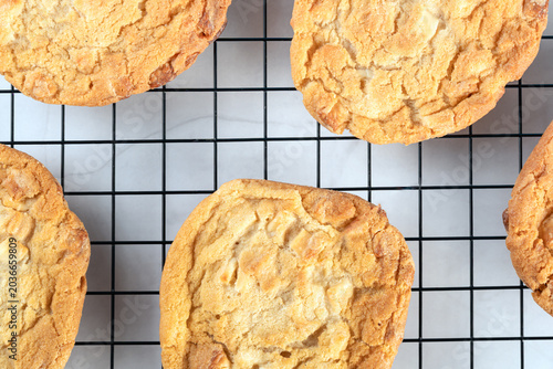 Top down view of delicious homemade chocolate chip cookies arranged neatly on a metal cooling grid with clean bright workspace