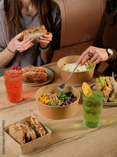 Girl eating sandwich. Girl eating salad. Healthy food table
