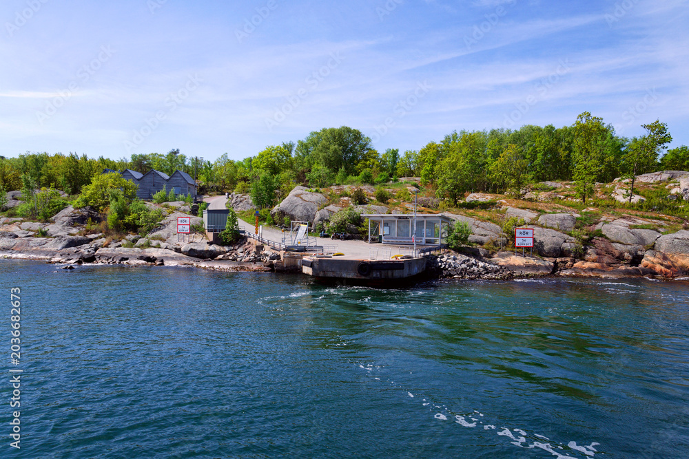 Fototapeta premium Beautiful holiday cottages on shore of Gothenburg archipelago islands, Gothenburg Minucipality, Vastra Gotaland County, Sweden, sunny day