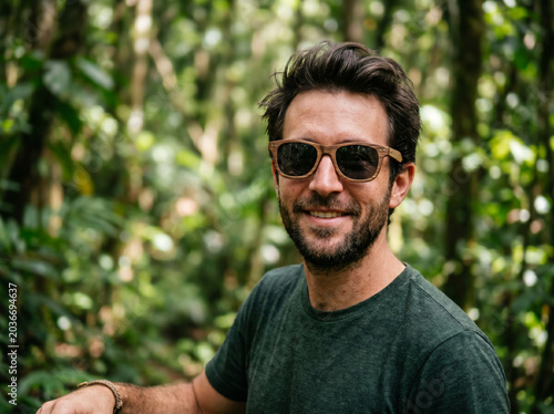 Smiling man in sunglasses outdoors in a green park