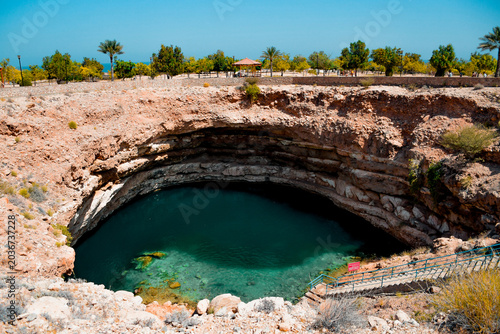 Cuadro en lienzo Hawiyat Najm sinkhole filled with emerald green water under a blue sky