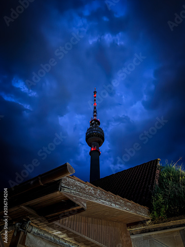 Telecommunication tower of Ruse, Bulgaria seen from behind the roof of nearby house during late evening hours