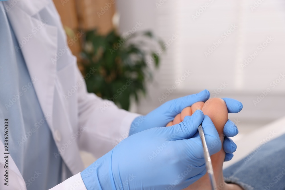 Naklejka premium Woman undergoing toenail treatment during visit to podiatrist in clinic, closeup
